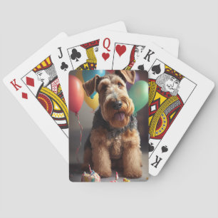 Airedale dog with cake and balloons playing cards