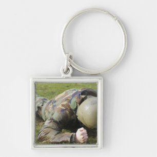 Airman crawls through a wet field key ring