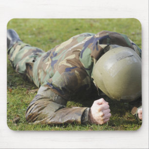 Airman crawls through a wet field mouse mat