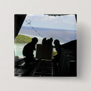 Airmen push out a pallet of donated goods 15 cm square badge