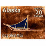 Alaska Dog Sled Mail Postage Stamp Photo Sculpture Magnet<br><div class="desc">Features the 20 Nugget postage stamp issued by an imaginary independant Alaska commemorating the resumption of dog sled. A modern dog sled is depicted superimposed on a caribou (reindeer) fur background image. The sled has a blue sled bag sporting Alaska's flag and text reading "ALASKA POSTAL SERVICE." Additional text reads,...</div>