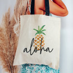 Aloha Tropical Watercolor Pineapple Tote Bag<br><div class="desc">Cute tote bag design features a pineapple illustration,  the traditional symbol of hospitality,  in sheer,  pretty watercolors. The Hawaiian greeting "Aloha" is overlaid in handwritten lettering. Makes a great welcome bag or favour for Hawaii weddings or destination weddings!</div>