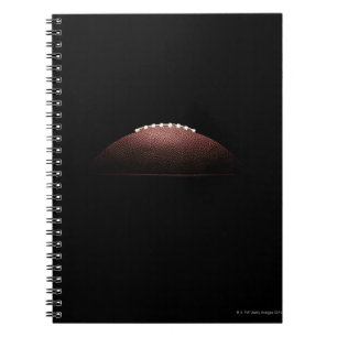 American football ball on black background notebook