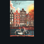 Amsterdam Canal Houses Canvas Print<br><div class="desc">An illustration of Amsterdam the capital city of The Netherlands features charming,  colourful houses along a canal,  a white bicycle in the foreground,  and autumn trees under a blue sky with birds flying.</div>