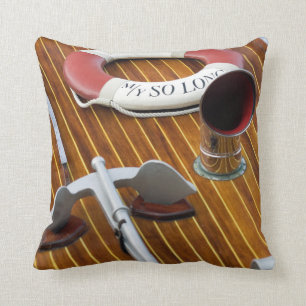 An Anchor And A Life-Buoy On A Wooden Boat Cushion
