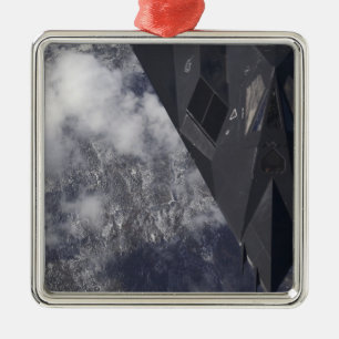 An F-117A Nighthawk flies high over the mountai Metal Tree Decoration