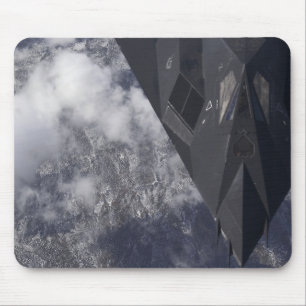 An F-117A Nighthawk flies high over the mountai Mouse Mat