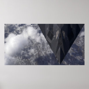 An F-117A Nighthawk flies high over the mountai Poster