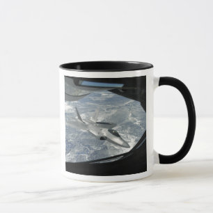 An F-22 Raptor banks away from a KC-135 Mug