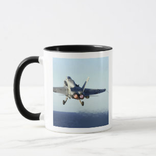 An F/A-18C Hornet launches from the flight deck Mug