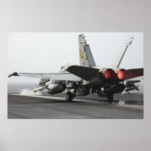 An F/A-18C Hornet launches from the flight deck Poster