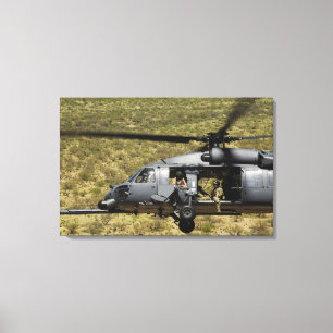An HH-60 Pave Hawk flies over the desert Canvas Print