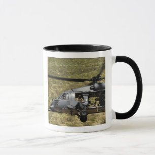 An HH-60 Pave Hawk flies over the desert Mug
