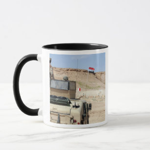 An instructor watches as an Iraqi army soldier Mug