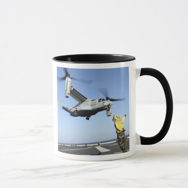 An MV-22 Osprey launches from the USS Nassau Mug (Right)