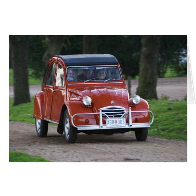 An old red Citroen 2CV car with a smiling woman (Front Horizontal)