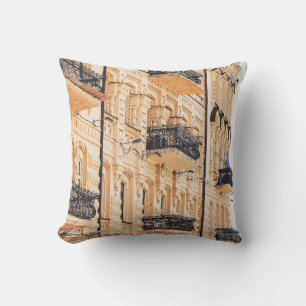 An old yellow house with wrought-iron balconies. f cushion