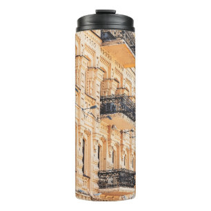 An old yellow house with wrought-iron balconies. f thermal tumbler
