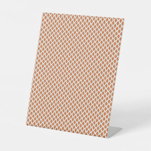 an orange and white geometric pattern pedestal sign