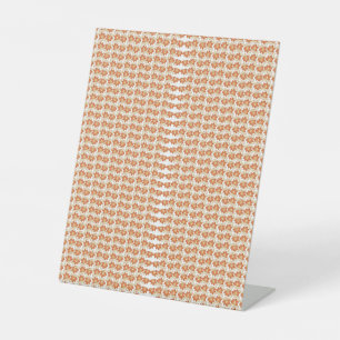 an orange and white pattern on a white background pedestal sign