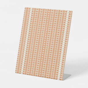 an orange and white striped background with small  pedestal sign