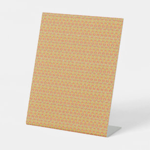 an orange and yellow background with a pattern pedestal sign