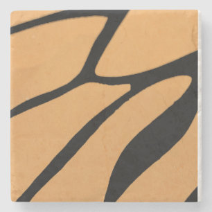 an orange surface with irregular black lines stone coaster