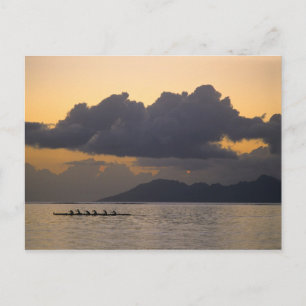 An outrigger canoe team practices off the coast postcard