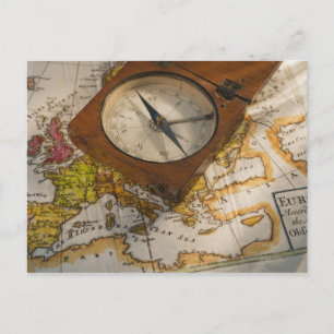 Antique compass on map postcard