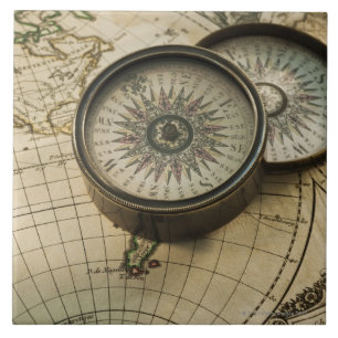 Antique compass on map tile