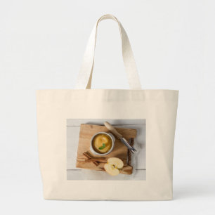 Applesauce with cinnamon in stoneware bowl large tote bag