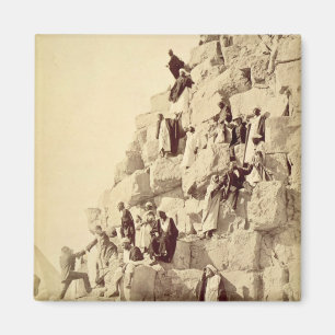 Arabs assisting tourists to climb the pyramids at magnet