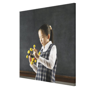 Asian girl looking at molecule model canvas print