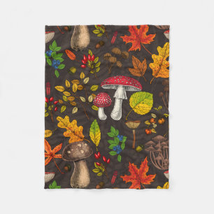 Autumn mushrooms, leaves, nuts and berries on blue fleece blanket