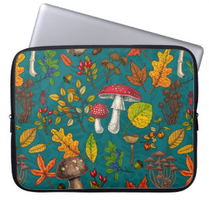 Autumn mushrooms, leaves, nuts and berries on blue laptop sleeve