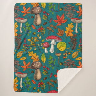 Autumn mushrooms, leaves, nuts and berries on blue sherpa blanket