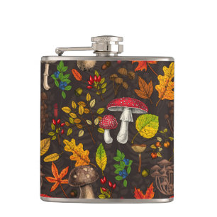 Autumn mushrooms, leaves, nuts and berries on dark hip flask
