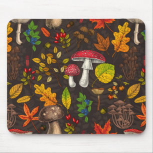 Autumn mushrooms, leaves, nuts and berries on dark mouse mat