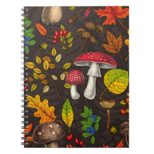 Autumn mushrooms, leaves, nuts and berries on dark notebook