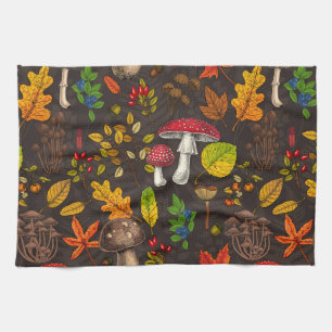 Autumn mushrooms, leaves, nuts and berries on dark tea towel