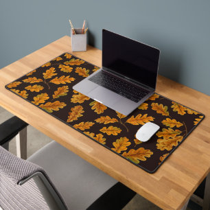 Autumnal oak leaves on dark brown desk mat