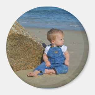 Baby by the ocean pondering. magnet