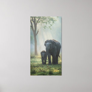 Baby elephant walking close to mother in misty  canvas print