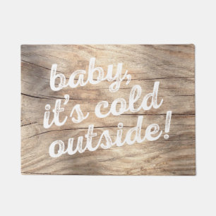 baby, it's cold outside! on light wood background doormat