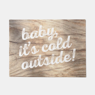 baby, it's cold outside! on light wood background doormat