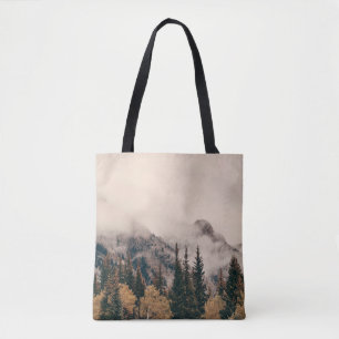 Banff national park foggy mountains and forest in tote bag