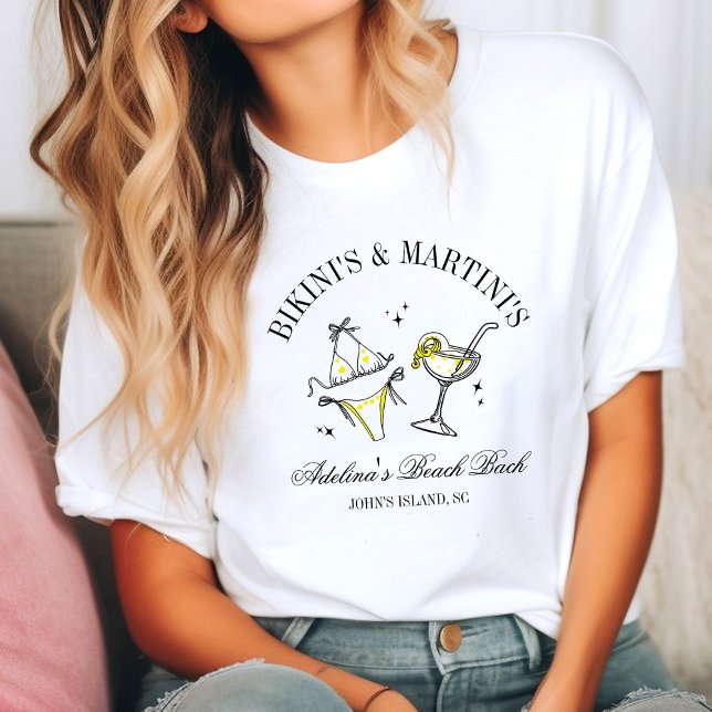 Beach Bachelorette Party Favour Social Club T-Shirt (Woman in a casual setting wearing a white T-shirt with a fun design of a bikini and martini glass. )