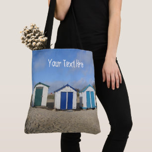 Beach huts blue skies sand english seaside beach tote bag