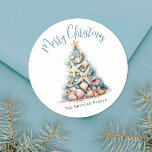 Beach Merry Christmas Classic Round Sticker<br><div class="desc">Celebrate in sunny style with this festive round sticker, perfect for your tropical holiday celebration. A large Christmas tree made of beach shells, starfish, and coral sits in the centre, bringing a fun and whimsical coastal vibe to your event. The design features a teal blue and tan colour palette that...</div>