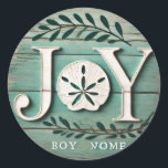 Beach Sand Dollar Christmas Joy Photo Ceramic Orna Classic Round Sticker<br><div class="desc">"Bring the warmth of the beach to your holiday decorations with this rustic JOY sand dollar ornament! Featuring a beautifully crafted sand dollar in place of the 'O' and subtle greenery with red berries, this ornament combines coastal charm with traditional holiday elements. Perfect for beach lovers, this ornament adds a...</div>